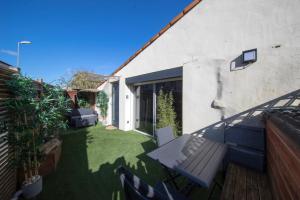 a small garden with a bench on the side of a house at LOVE Suites & SPA "Le Loft" avec Jacuzzi privatif in Médis