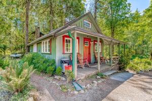 una piccola casa verde e rossa nel bosco di The Cozy Cabin a Welches