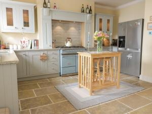 a kitchen with a center island with a vase of flowers at Invermay in Anstruther