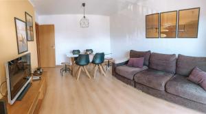 ein Wohnzimmer mit einem Sofa und einem Tisch in der Unterkunft Beach House Carmen in Monte Gordo