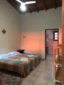 Zimmer mit einem Bett und einem Spiegel in der Unterkunft Pousada Vila Cambury in Camburi