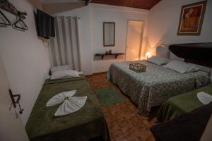 um quarto de hotel com duas camas e uma televisão em Hotel Fazenda Monteiro em Conservatória