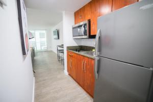 una cocina con nevera de acero inoxidable y armarios de madera en High Rise Brickell Modern Studio, en Miami