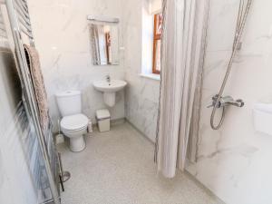 a white bathroom with a toilet and a sink at 3 The Stables in Haven Street +12 photos