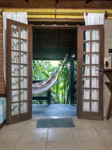 an open door with a hammock in a room at Morada Crisálida in Praia do Rosa