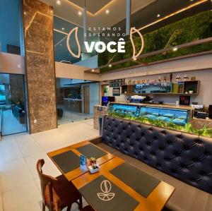 ein Restaurant mit einer Bank und einem Tisch in der Lobby in der Unterkunft Manaíra Apart Hotel - Flat 201 in João Pessoa