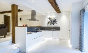 a kitchen with white cabinets and a sink at The Shippon Cottage in Kendal