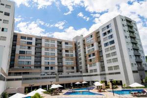 een groot appartementencomplex met een zwembad en parasols bij Temporada Resort Park Veredas com rio quente ao fundo in Rio Quente