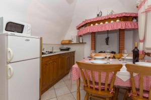 een keuken met een tafel en een witte koelkast bij Villa Josip - private swimming pool in Labin