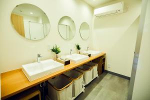uma casa de banho com dois lavatórios e dois espelhos em ゲストハウス酒坊多満自慢 em Fussa