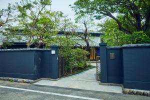 una cerca azul delante de una casa en ゲストハウス酒坊多満自慢 en Fussa