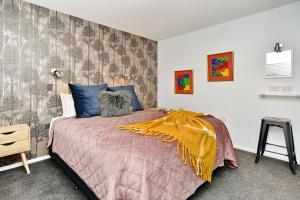 ein Schlafzimmer mit einem Bett mit einer gelben Decke darauf in der Unterkunft Brockworth Place - Christchurch Holiday Homes in Christchurch