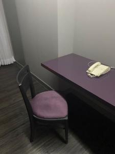 a purple desk with a chair and a phone at Grand Mercure Brasília - Ap Particular 112 in Brasilia