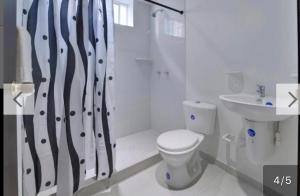 Baño blanco con aseo y lavamanos en Tropical Breeze Apartamentos en San Andrés