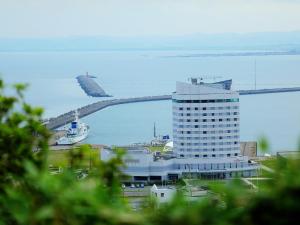 
a large jetliner flying over a large body of water at Surfeel Hotel Wakkanai in Wakkanai
