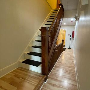a hallway with a wooden staircase in a house at Baseball Town Motel in Cooperstown