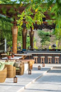 a patio with benches and tables and trees at Andaz Bali, By Hyatt in Sanur