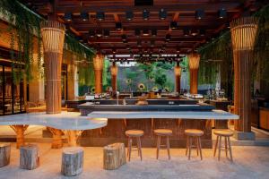 a restaurant with two tables and stools and a bar at Andaz Bali, By Hyatt in Sanur