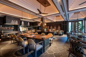 a restaurant with a large wooden table and chairs at Andaz Bali, By Hyatt in Sanur
