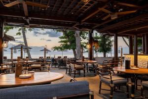 a restaurant with tables and chairs and a view of the ocean at Andaz Bali, By Hyatt in Sanur