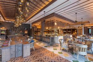 a restaurant with tables and chairs in a room at Andaz Bali, By Hyatt in Sanur