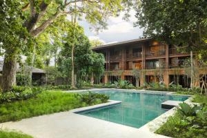 an external view of a house with a swimming pool and trees at Andaz Bali, By Hyatt in Sanur