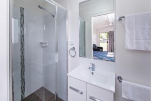 a bathroom with a shower, sink, and mirror at Kingaroy Holiday Park in Kingaroy