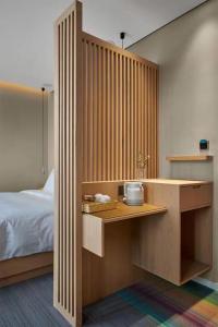 a bedroom with a bed and a wooden desk at Ebo Hotel in Hangzhou