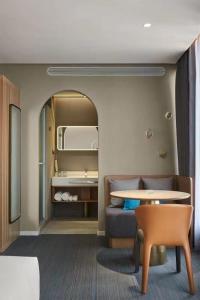 a room with a couch and a table and a mirror at Ebo Hotel in Hangzhou