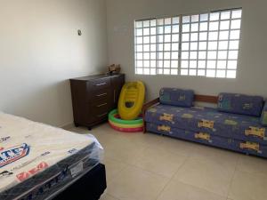 1 Schlafzimmer mit 2 Betten, einem Schreibtisch und einem Tisch in der Unterkunft Casa de Campo em Alexania GO - Bela Vista do Corumbá in Alexânia