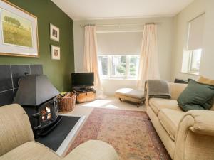 a living room with a couch and a fireplace at Gable End in High Yewdale