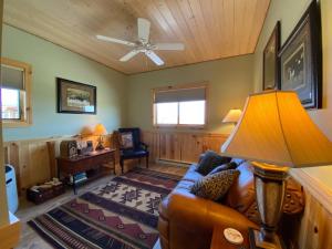 uma sala de estar com um sofá e uma ventoinha de tecto em Gold Bar Ranch Bungalow em Clark