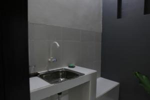 a white bathroom with a sink and a toilet at Adikara Renon in Denpasar