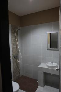ein Badezimmer mit einem Waschbecken, einem WC und einem Spiegel in der Unterkunft Adikara Renon in Denpasar