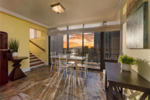 een eetkamer met een tafel en een balkon bij Oceanview Penthouse Suite in Honolulu