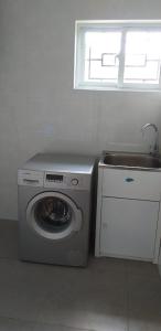 a kitchen with a washing machine and a sink at Baie Lazare View in Baie Lazare Mahé