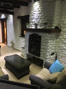 a living room with a stone fireplace and a couch at Hostal Mulhacen in Trevélez