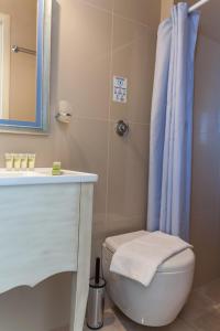 a bathroom with a toilet and a blue shower curtain at Villa Nostalgia Lentas No4 in Lentas
