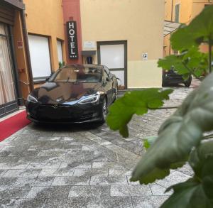 a black car parked in front of a building at Intra Hotel in Verbania