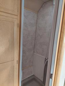 a shower with a glass door next to a cabinet at Vintage Nest by the Sea in Saraiķi