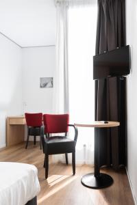 een kamer met een tafel, 2 stoelen en een bureau bij Hotel Hulsman in Venray