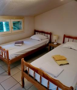 Campotel Du Jaur في Saint-Pons: سريرين في غرفة بها نافذتين