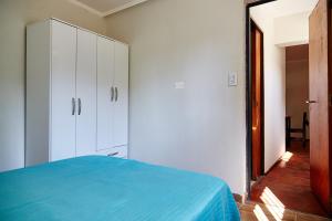 1 dormitorio con 1 cama azul y armario blanco en Departamentos Victoria en Paraná