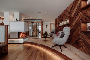 a living room with a fireplace and a chair at PoSt Boutique Apartments in Maria Alm am Steinernen Meer