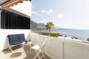 einen Balkon mit Stühlen und Meerblick in der Unterkunft Home2Book SeaFront Studio Punta del Hidalgo in Punta del Hidalgo