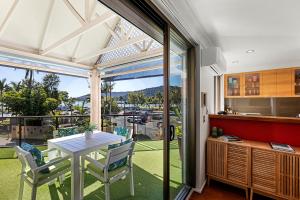 a kitchen and dining room with a table and chairs at Montipora Unit 3 - In the heart of Airlie, wi-fi and Netflix in Airlie Beach