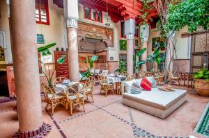 a patio with tables and chairs in a building at Riad Chorfa in Marrakesh