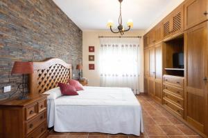 a bedroom with a bed and a brick wall at Home2Book Charming Apartment Los Realejos in Los Realejos