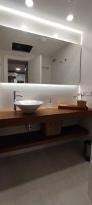 baño con lavabo y espejo grande en GRUPO LIMCOTEL PERLAS dE LA AXERQUIA, en Córdoba