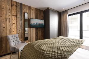 a bedroom with a bed and a tv on a wall at Seven Reasons / Panorama View in Hart im Zillertal